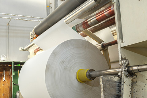 Smooth white paper winding onto a roll following sheet formation